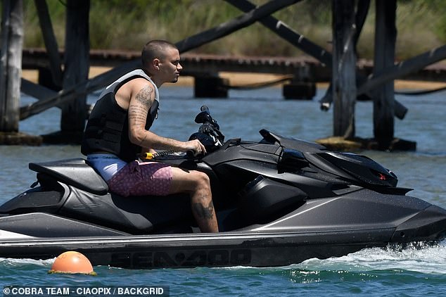 Romeo was spotted taking a jet ski out for a ride, sporting patterned purple swimming trunks