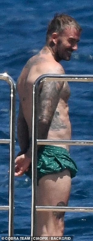 David's vast tattoo collection was on show as he hiked up his swimming shorts to work on his tan