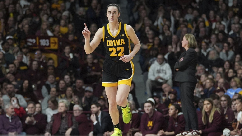 Iowa guard Caitlin Clark (22) points after an Iowa basket scored during the first half of a game against Minnesota, Wednesday, Feb. 28, 2024, in Minneapolis. (AP Photo/Abbie Parr)