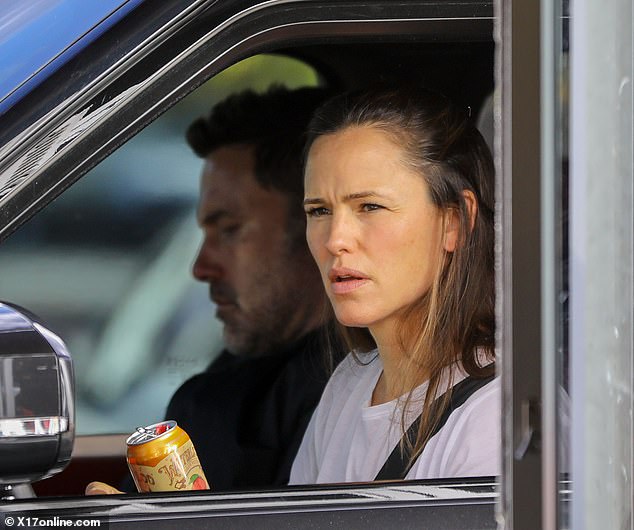 Tense times: Jennifer Garner took control of the wheel on Friday as she drove her downcast ex-husband, Ben Affleck, in his car, to a 'remote hotel' - following an argument they were seen having outside her home earlier in the day